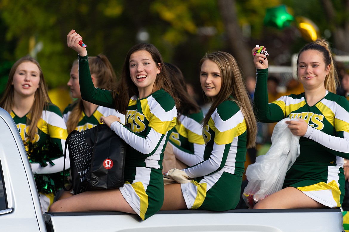 Whitefish cheerleaders toss candy out during the homecoming parade on Friday.