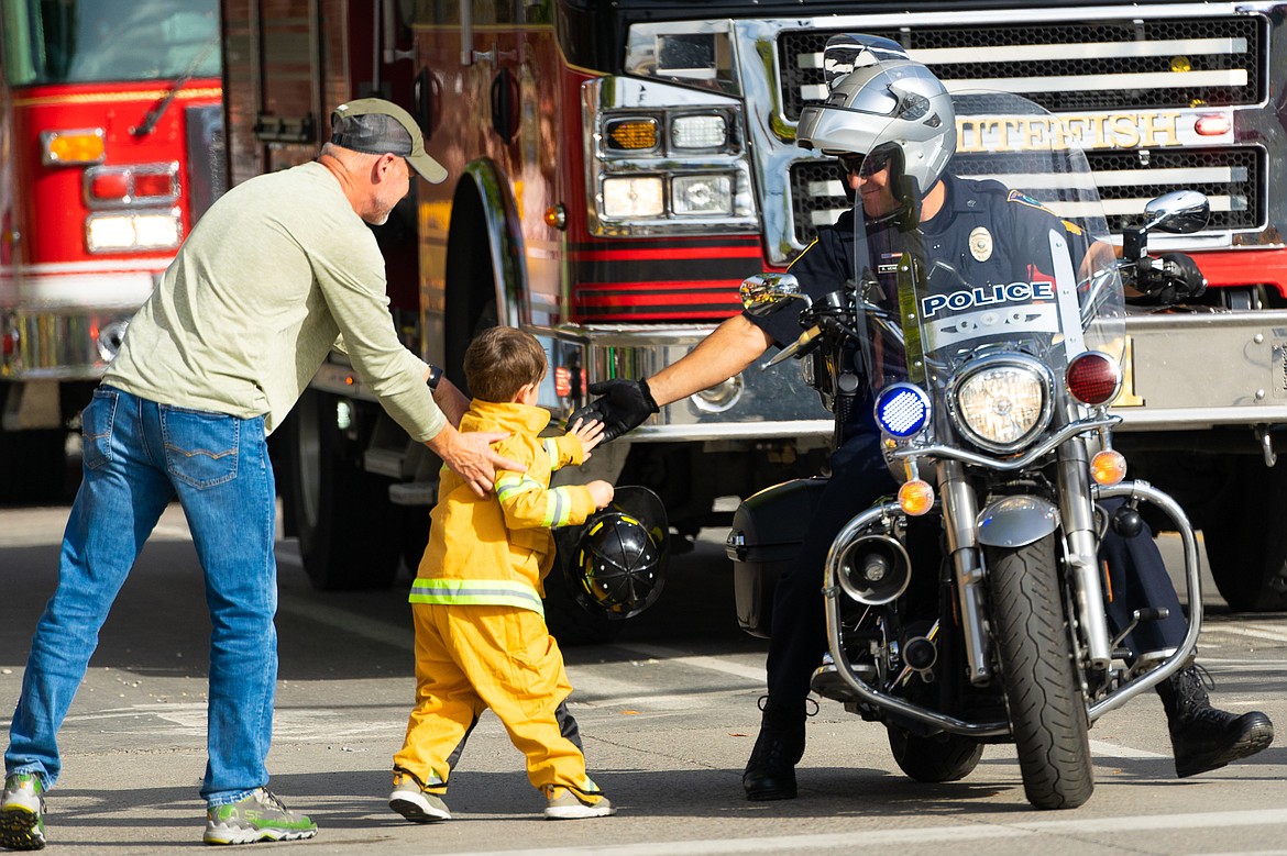 A young fan of Whitefish&#146;s emergency services high fives Whitefish Police Sgt. Rob Veneman during the homecoming parade on Friday.