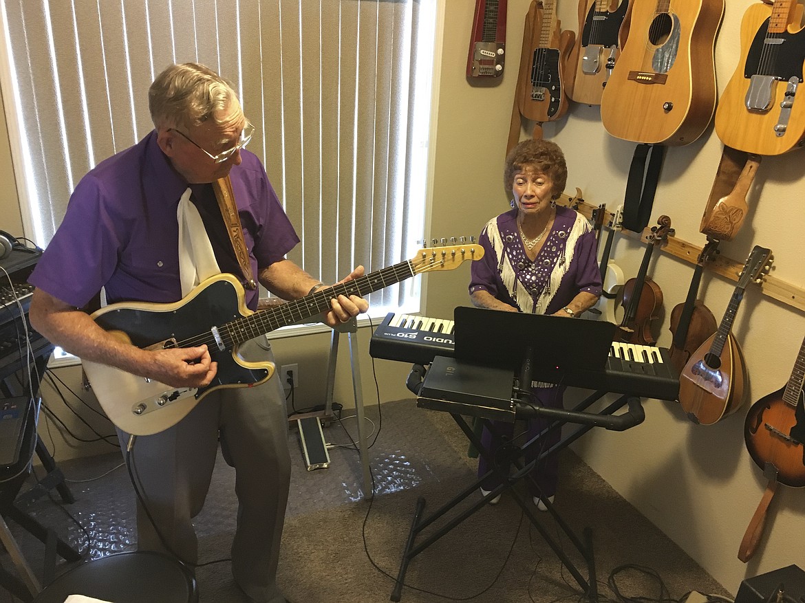 Gil and Erma Prier of Columbia Falls play a tune in their music room, surrounded by 20-some instruments on the walls. (Ashley Fox photos/Lake County Leader)