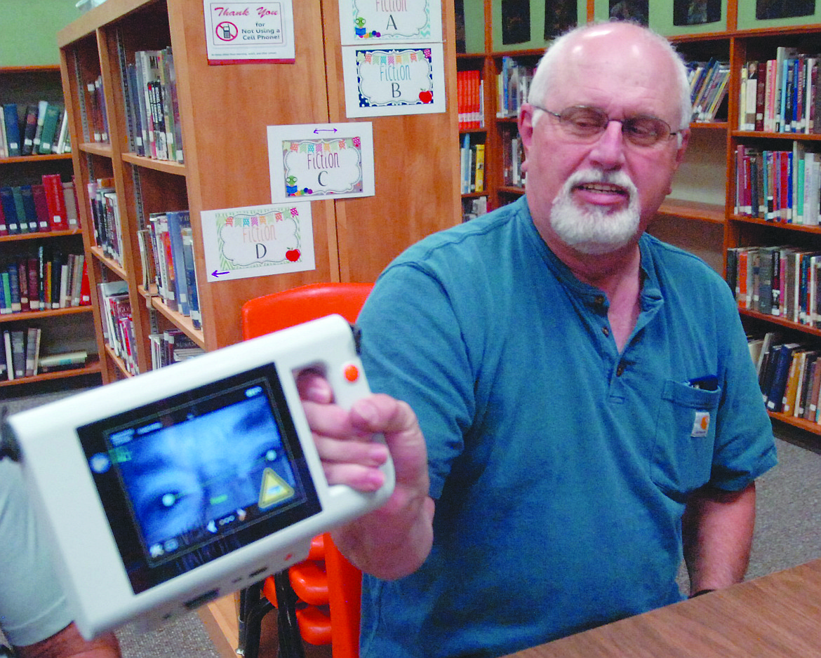 Chuck Wassinger, former treasurer and current member of the Plains Lions Club, shows how the image of a child&#146;s eyes appears on the new plusoptix machine will be using this fall for student vision screening.