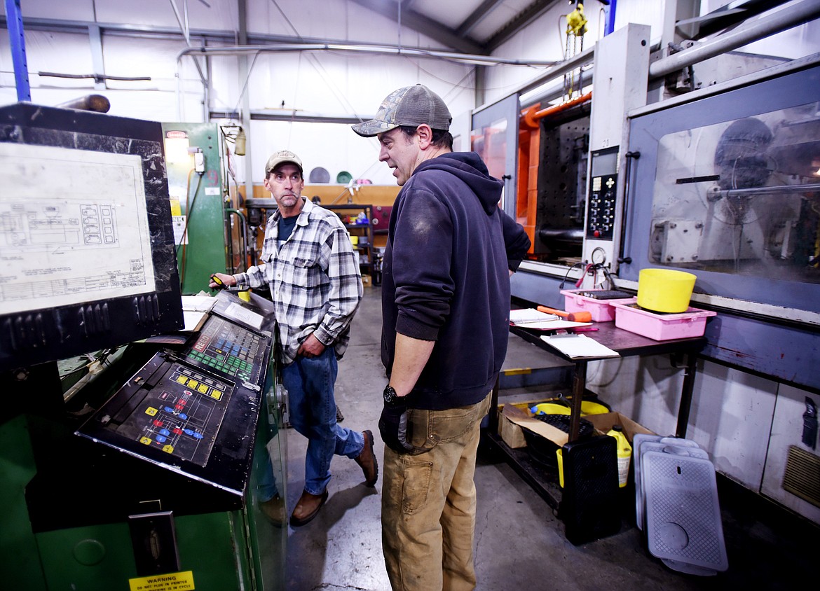 Jason Boudreaux, front, trains Steve Belstad on the use of the 400 ton press at Northern Plastics on Thursday, September 27, in Kalispell.(Brenda Ahearn/Daily Inter Lake)