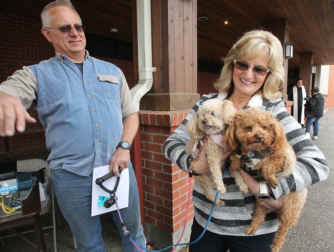 Joannie and Darryl Burnett of Post Falls smile after their poodles April May, left, and Sir Charles receive a blessing Saturday at St. Pius X Catholic Church during the Blessing of the Animals. &#147;They&#146;re God&#146;s creatures too and they&#146;re like our kids,&#148; Joannie said. &#147;God&#146;s blessed us with them.&#148;