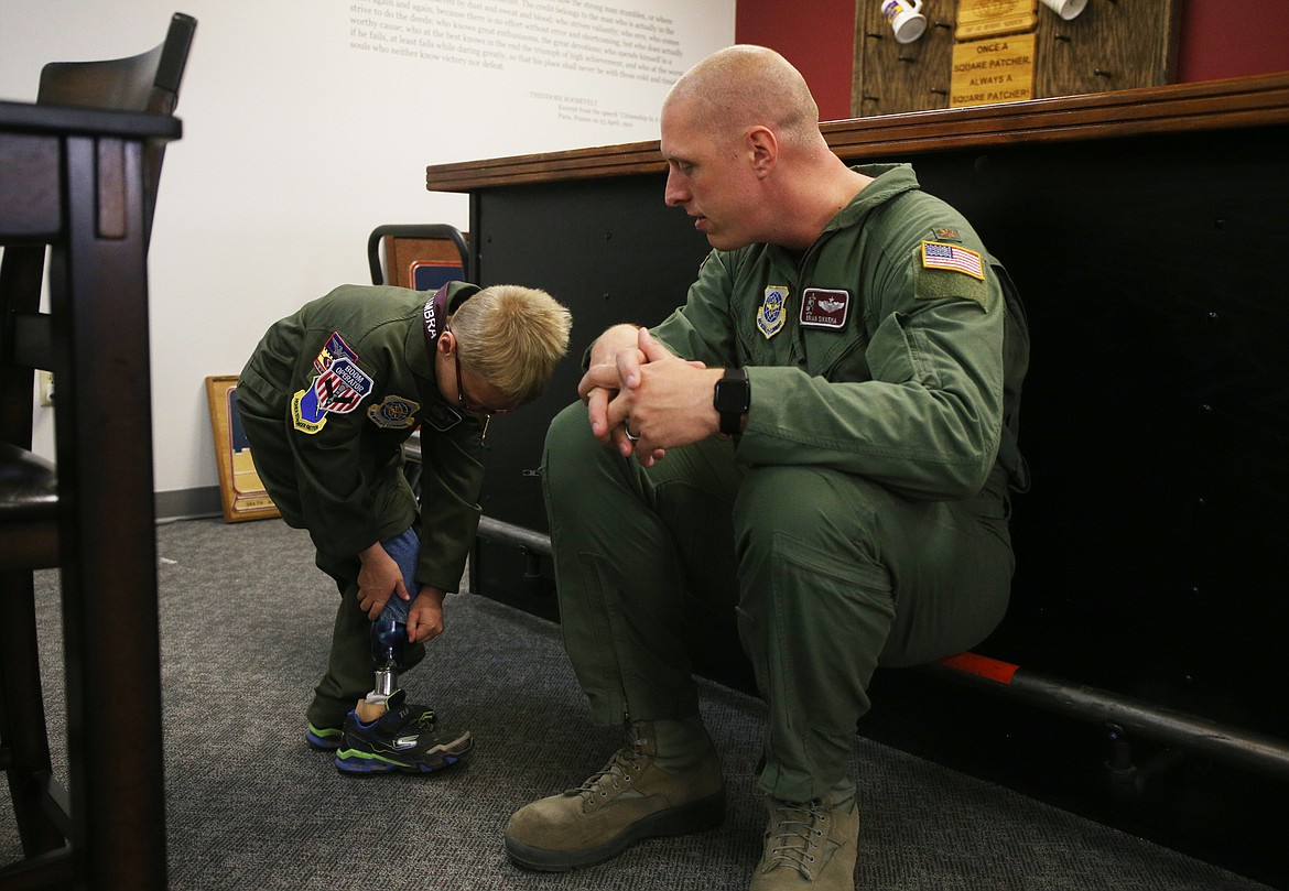 Isaiah Watkins, 7, shows his prosthetic leg to USAF Major Brian Sikkema during his Pilot for a Day visit with the 384th Air Refueling Squadron at Fairchild Airforce Base outside Spokane on Friday. Isaiah was born with a rare condition called fibular hemimelia. (LOREN BENOIT/Press)