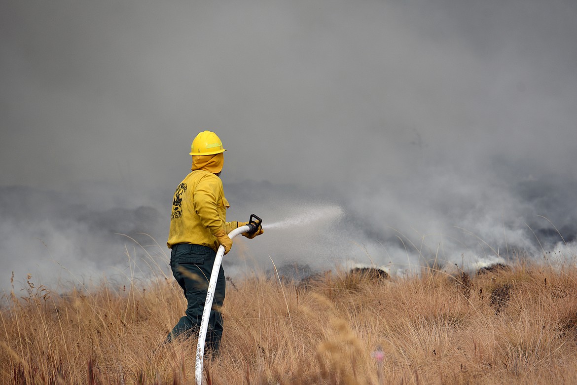 A firefighter battles a fire in a field off Foys Lake Road in Kalispell on Tuesday. (Casey Kreider/Daily Inter Lake)