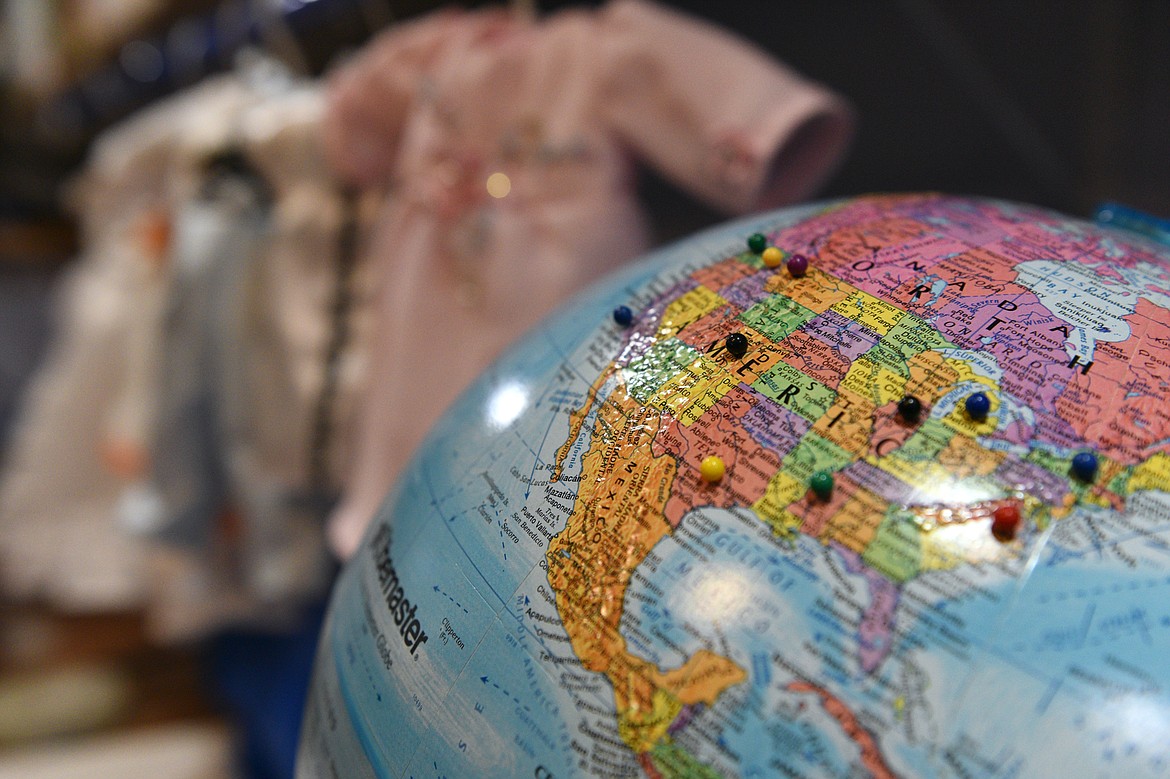 Colored pins on a globe in Connee Jones&#146; basement workspace show locations around the world where she has shipped her angel gowns. (Casey Kreider/Daily Inter Lake)