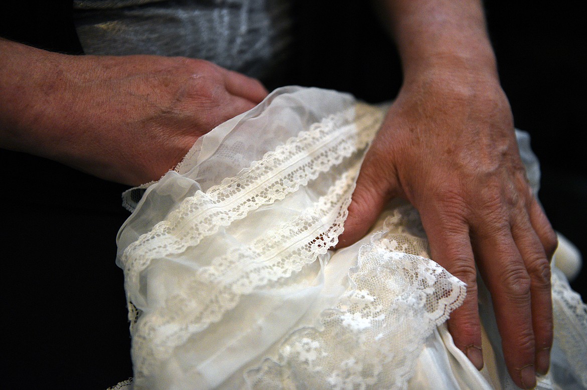 Connee Jones holds an angel gown in the basement workspace of her home in Kila on Wednesday, Oct. 3. (Casey Kreider/Daily Inter Lake)