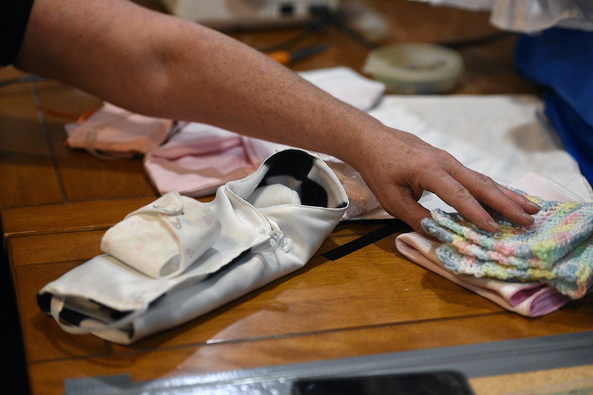 Connee Jones displays tiny angel gowns and blankets at her workspace in her home in Kila on Wednesday, Oct. 3. (Casey Kreider/Daily Inter Lake)