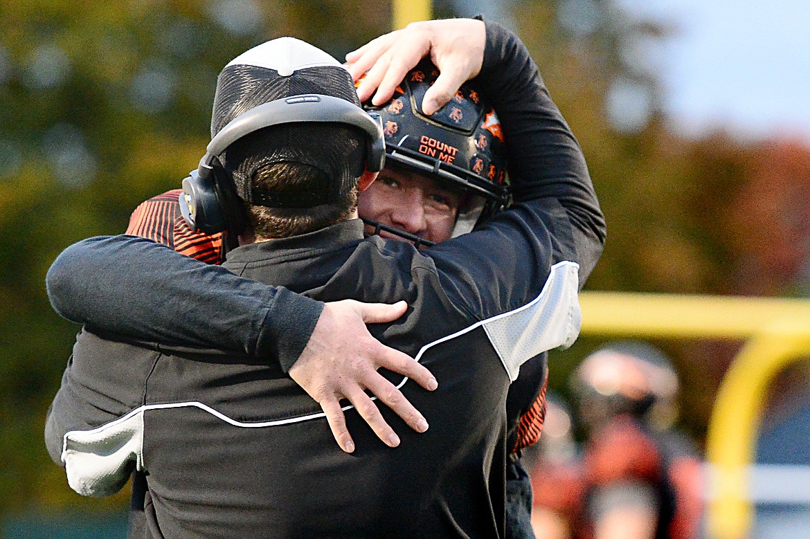 Flathead quarterback Jaden MacNeil gets a hug from head coach Kyle Samson after MacNeil's 62-yard first-quarter touchdown run against Missoula Big Sky at Legends Stadium on Friday. (Casey Kreider/Daily Inter Lake)