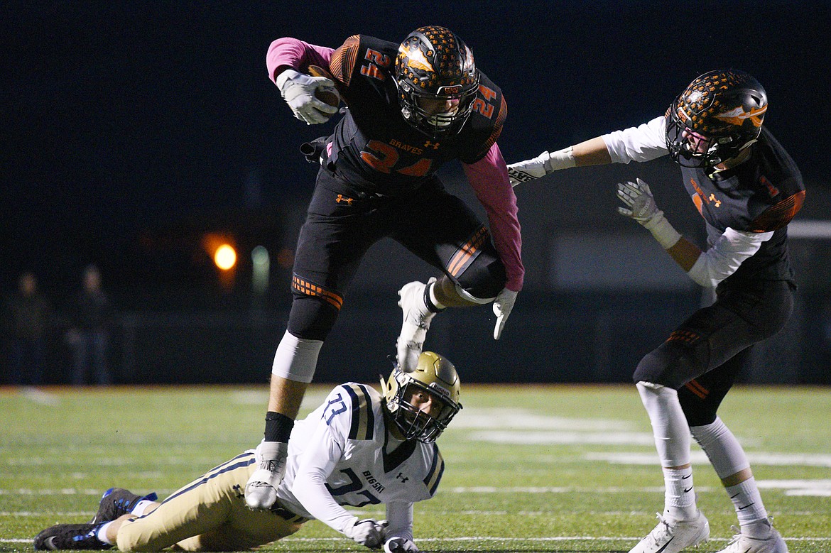 Flathead running back Blake Counts (24) hurdles Missoula Big Sky defender Dayton Evans (33) on a first quarter run that was called back due to a holding penalty at Legends Stadium on Friday. (Casey Kreider/Daily Inter Lake)