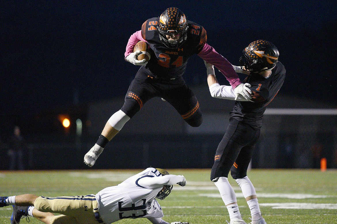 Flathead running back Blake Counts (24) hurdles Missoula Big Sky defender Dayton Evans (33) on a first quarter run that was called back due to a holding penalty at Legends Stadium on Friday. (Casey Kreider/Daily Inter Lake)