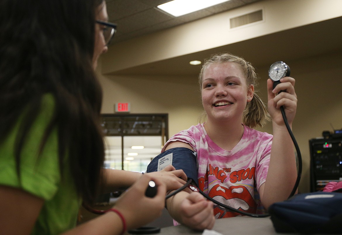 Lake City High School sophomore Noelani Kawamura, left, measures Abi Bradbury&#146;s blood pressure Tuesday afternoon at University of Idaho&#146;s 10th annual Women in Math and Science event at North Idaho College. (LOREN BENOIT/Press)
