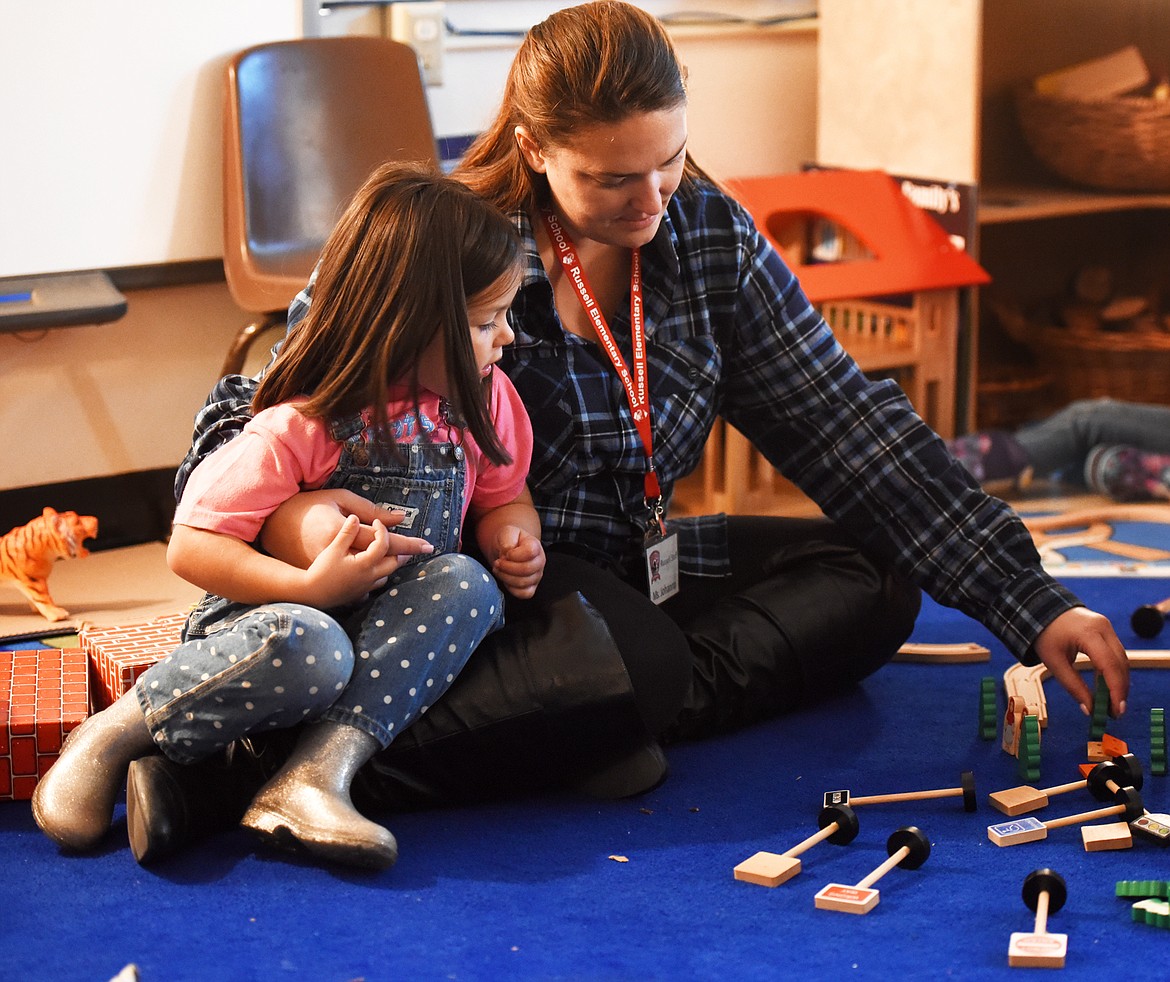 Paraeducator Johanna Schaeffer sits with Gabby Luke, 4, in the preschool room on Tuesday morning, Oct. 2, at Russell Elementary.