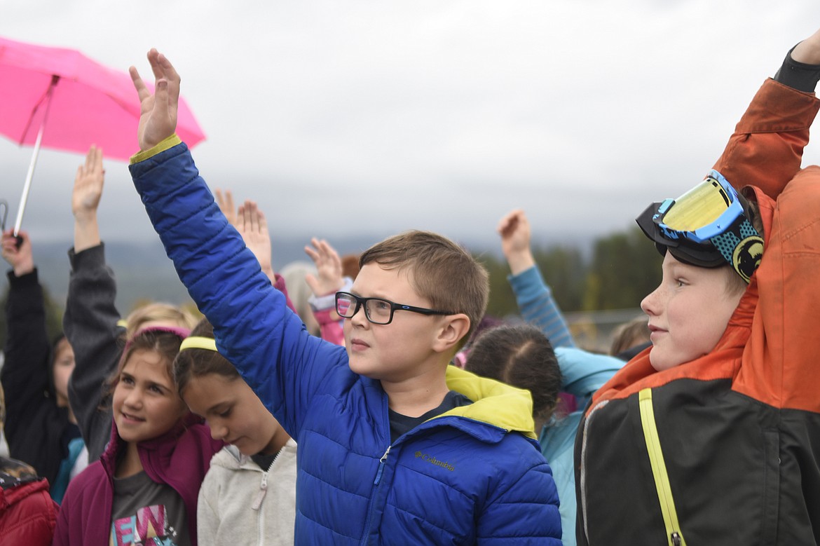 Third graders Hazel Remley and Maeve Alexander look on while Owen Culley and Asa French raise their hands during a tour of the equipment used in the construction of the new Muldown school during Construction Week last Tuesday.