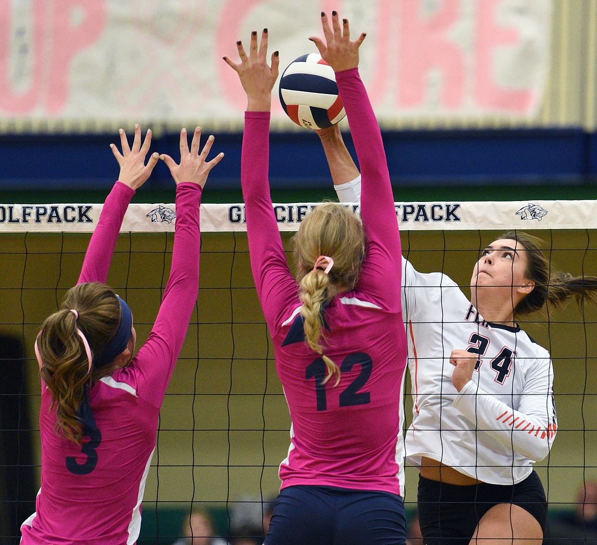 Flathead's Taylor Henley (24) goes for a kill against Glacier's Sidney Gulick (3) and Kali Gulick (12) during crosstown volleyball at Glacier High School on Thursday. (Casey Kreider/Daily Inter Lake)