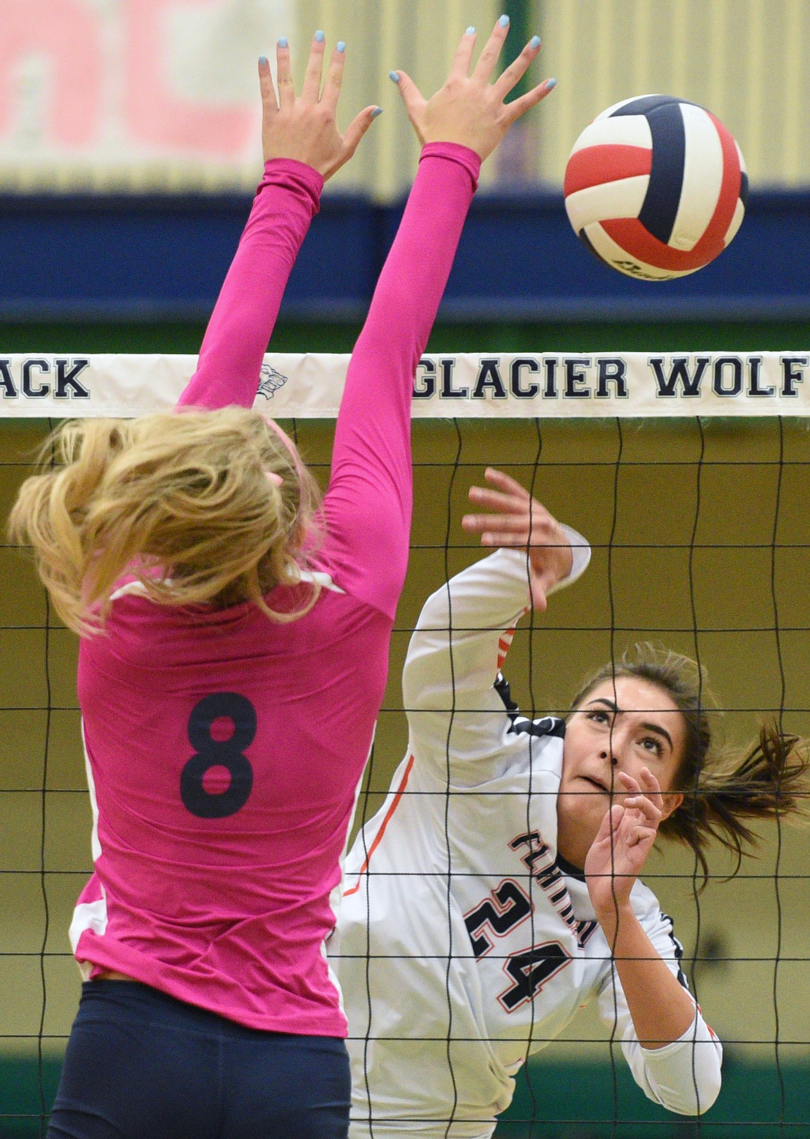 Flathead's Taylor Henley (24) goes for a kill against Glacier's Aubrie Rademacher (8) during crosstown volleyball at Glacier High School on Thursday. (Casey Kreider/Daily Inter Lake)