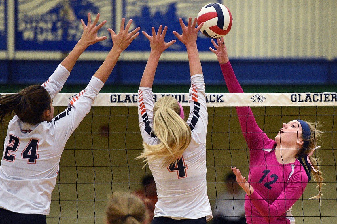 Glacier's Kali Gulick (12) goes for a kill against Flathead's Taylor Henley (24) and Jaylyn Fitch (4) during crosstown volleyball at Glacier High School on Thursday. (Casey Kreider/Daily Inter Lake)