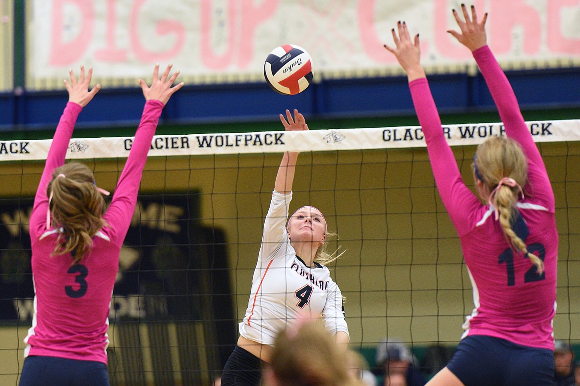 Flathead's Jaylyn Fitch (4) goes for a kill against Glacier's Sidney Gulick (3) and Kali Gulick (12) during crosstown volleyball at Glacier High School on Thursday. (Casey Kreider/Daily Inter Lake)