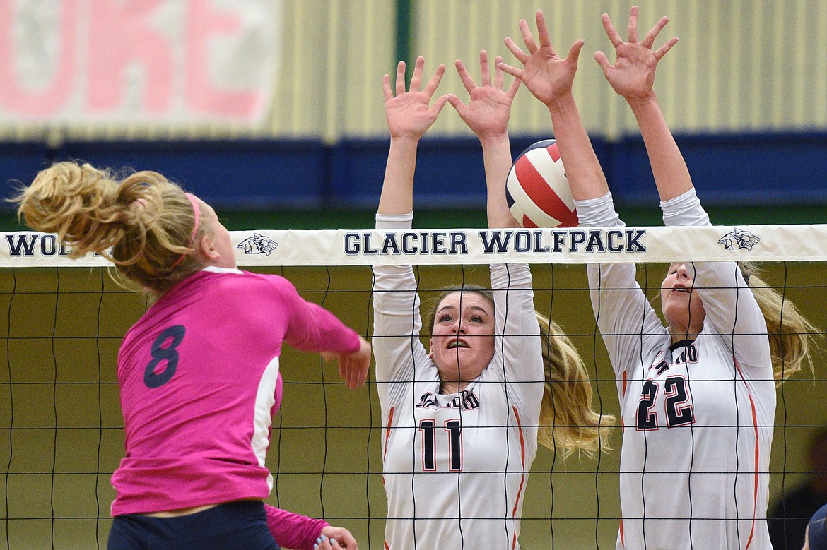 Flathead's Hannah O'Dell (11) and Julia Burden (22) go for a block against Glacier's Aubrie Rademacher (8) during crosstown volleyball at Glacier High School on Thursday. (Casey Kreider/Daily Inter Lake)