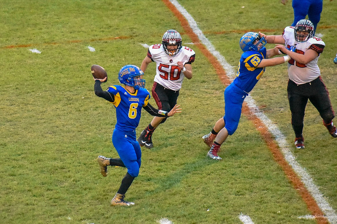 Libby junior quarterback Jeff Offenbecher throws a pass to senior running back JJ Davis for a 30 yard gain early in the first quarter of the Loggers' 42-14 homecoming win over Browning Friday. (Ben Kibbey/The Western News)