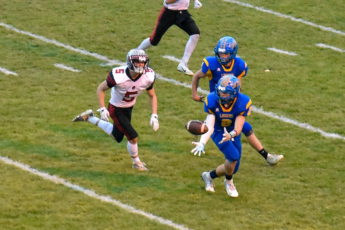 Libby senior running back JJ Davis receives a pass from junior quarterback Jeff Offenbecher, carrying the ball for a 30 yard gain early in the first quarter of the Loggers&#146; 42-14 homecoming win over Browning Friday. (Ben Kibbey/The Western News)