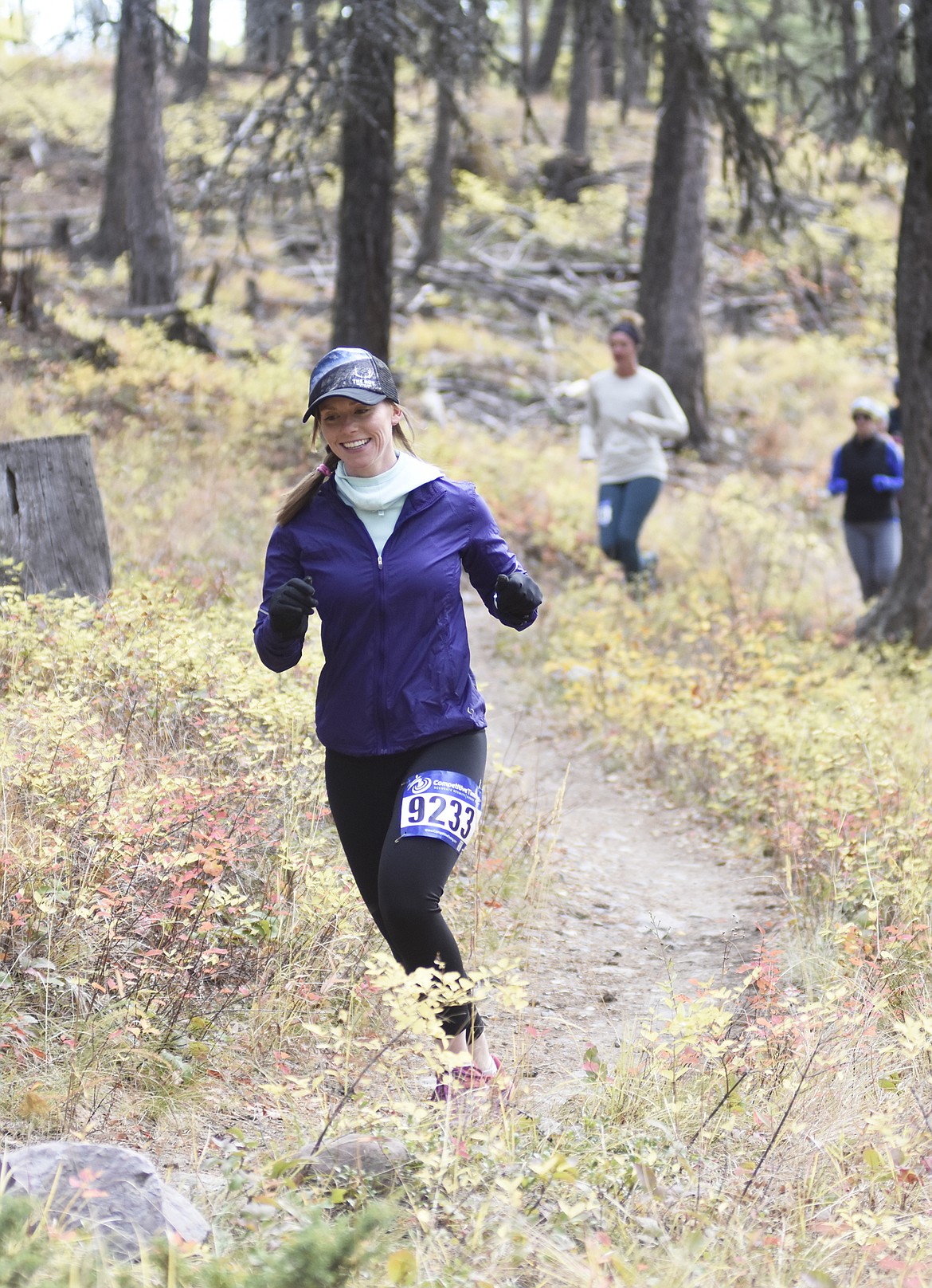 Elizabeth Richardson smiles as she rounds a corner during the start of the 10K during the Whitefish Trail Legacy Run Sunday morning. (Heidi Desch/Whitefish Pilot)