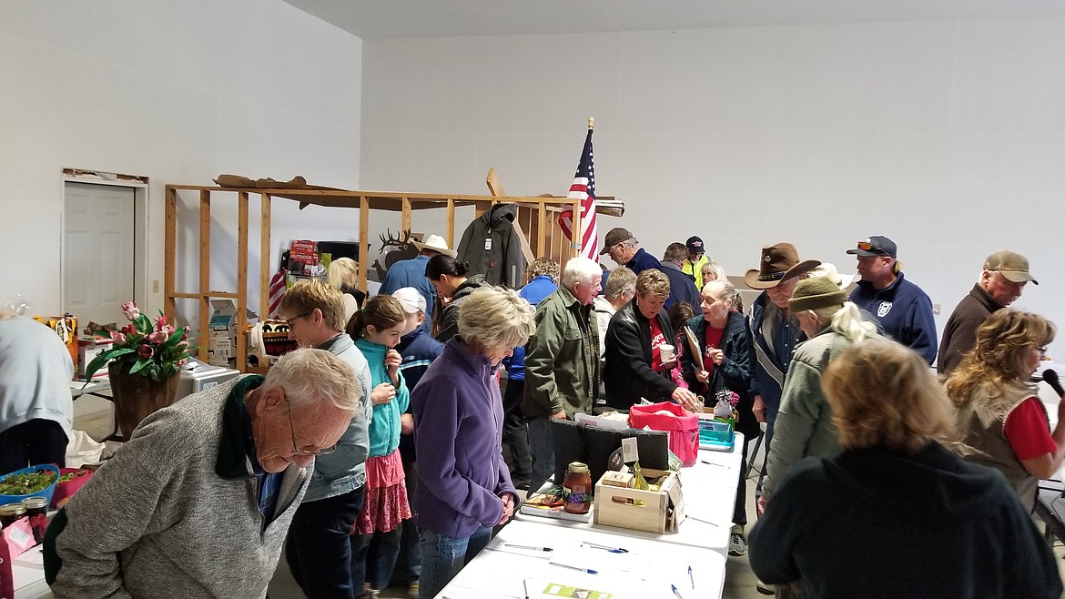 Photo by MANDI BATEMANDespite the chill in the air, people bid on the many donated items for the silent auction.