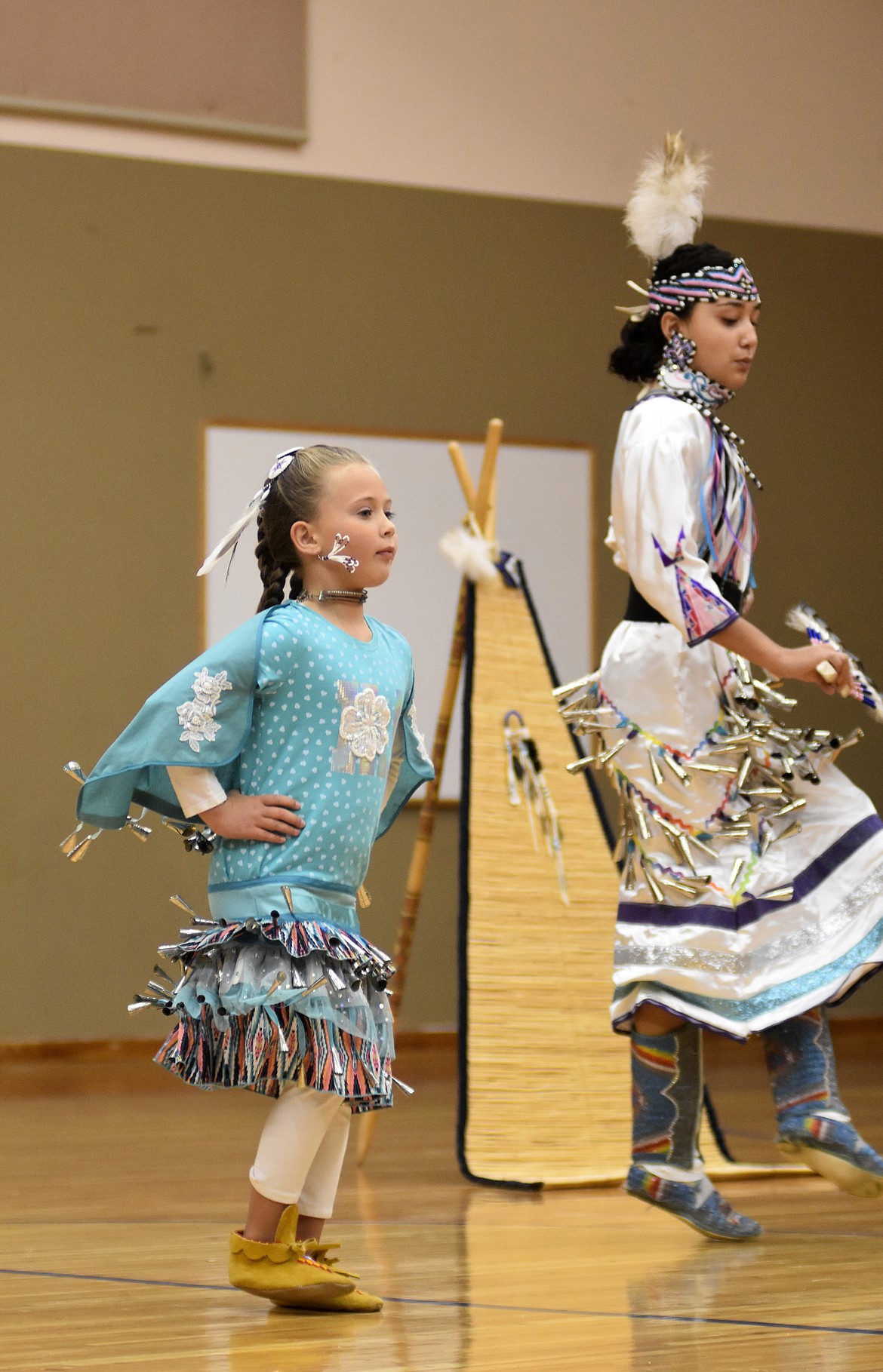 Maya DeMarias left, and with Payton Crossguns perform a jingle dance Thursday morning at Olney-Bissell School during a presentation by the Pikuni Legacy Dance Troupe from Browning. (Heidi Desch/Whitefish Pilot)