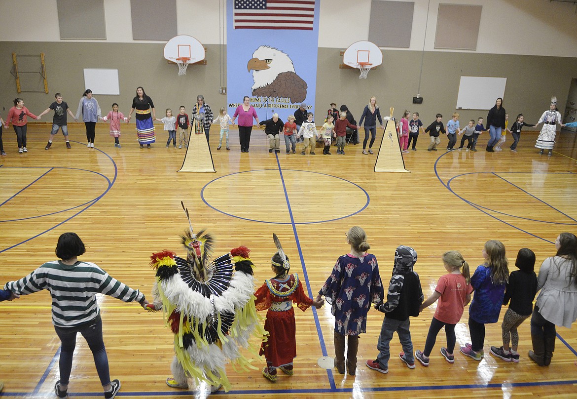 Olney-Bissell School students and dancers from the Pikuni Legacy Dance Troupe from Browning join hands for the friendship dance on Thursday morning in the school&#146;s gym. (Heidi Desch/Whitefish Pilot)