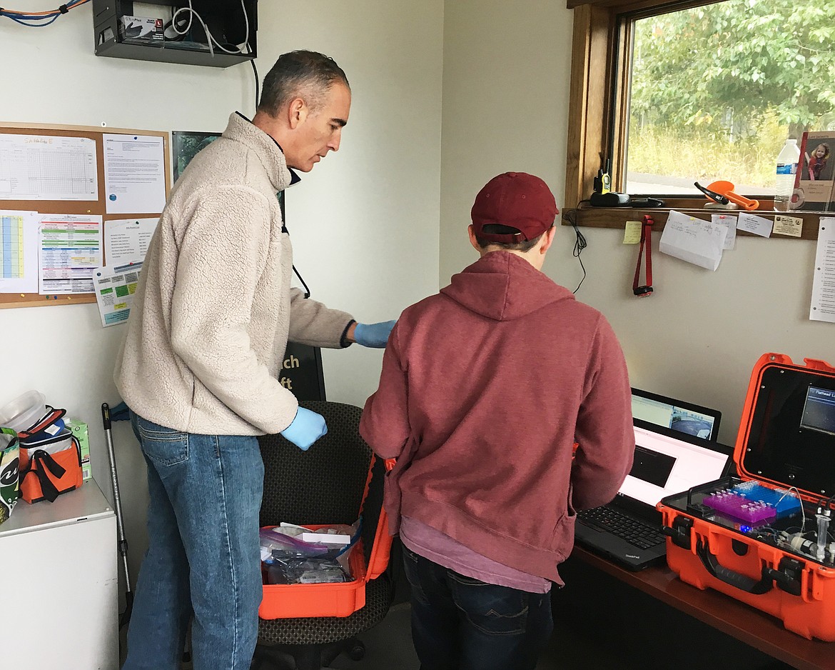 Cody Youngbull (left) and Zane Lindstrum from the Flathead Lake Biological Station utilize the eDNA tracker to test samples taken from boats at a boat inspection station on Whitefish Lake for invasive mussel DNA.