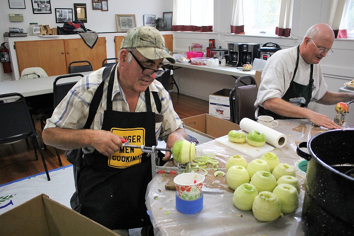 Mark Waseen (left) and Bill Mitchell (right) peel apples for a fundraiser for the Old School House in DeBorgia. The group peeled and sliced over 800 pounds of apples last week.