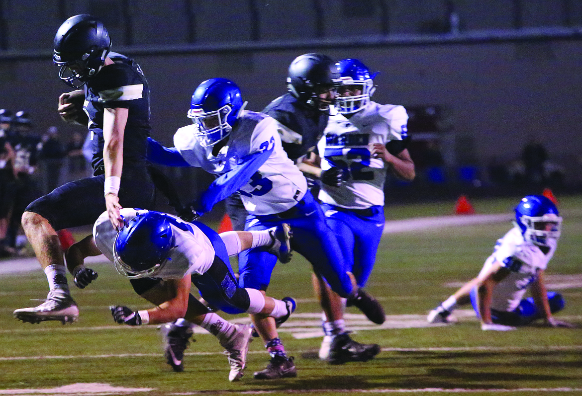 Connor Vanderweyst/Sun Tribune - Royal quarterback Sawyer Jenks (black) scrambles for extra yards against Warden.