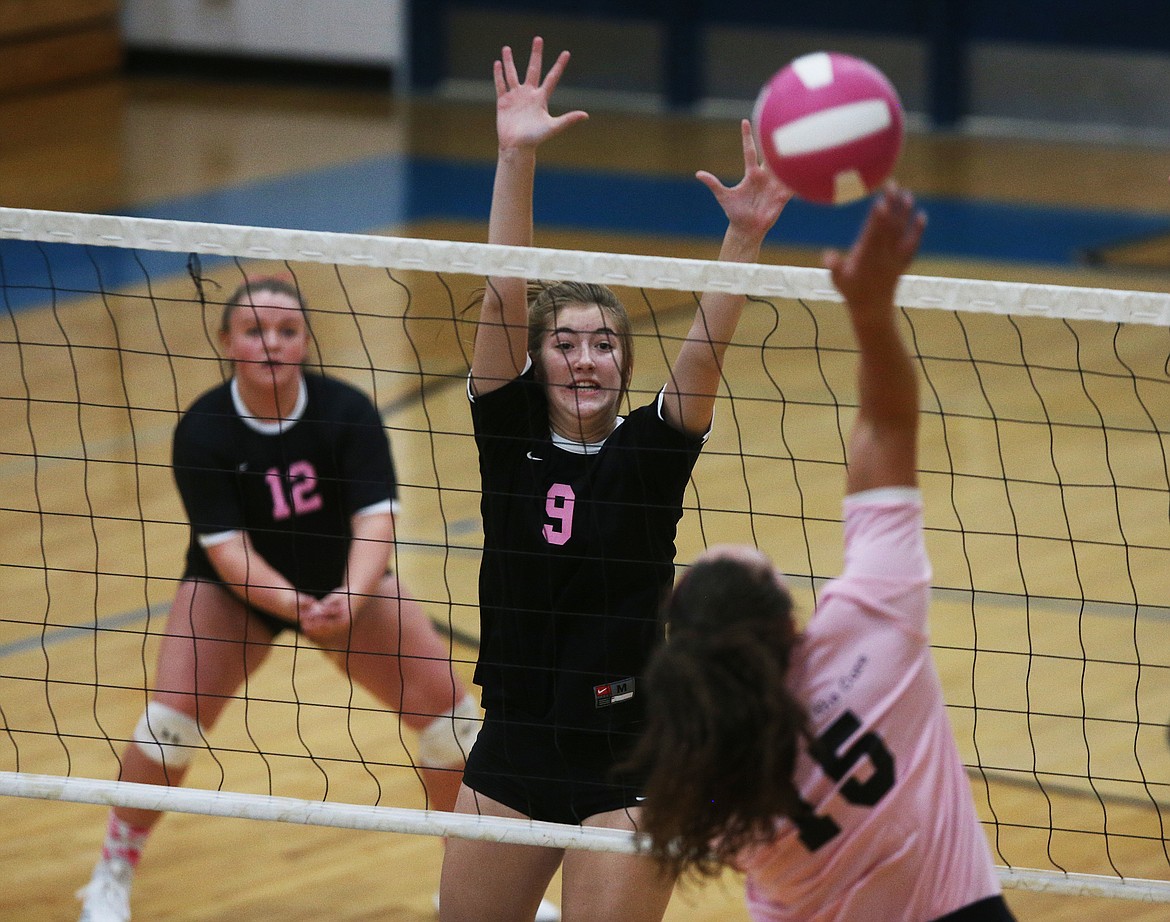 Rylee Hartwig (9) of Post Falls High goes for a block against Coeur d&#146;Alene&#146;s Kelly Horning.
