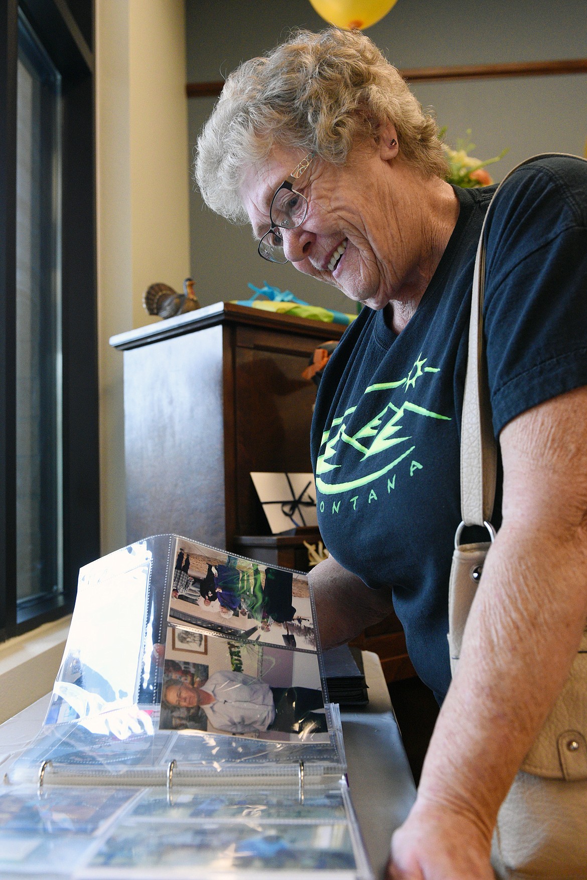 Geri Ax, a resident at Kalispell Senior Center, pages through a scrapbook full of photos and news clippings at the Center&#146;s 50th anniversary open house on Thursday. (Casey Kreider/Daily Inter Lake)