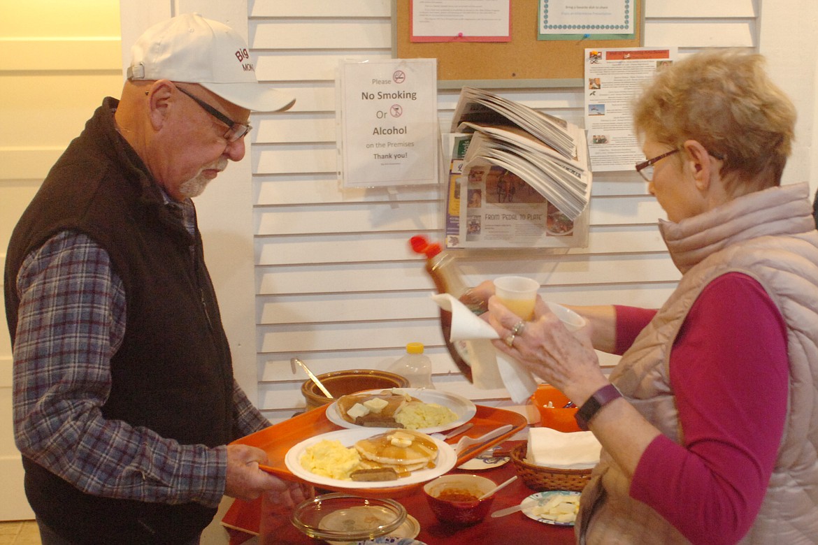 The Big Arm Association hosted a very popular breakfast last Saturday morning at the former Big Arm School, featuring pancakces, sausage, scrambled eggs, coffee and juice. Pictured are Al and Maureen Lenhart preparing to sit down to a delicious meal. (Joe Sova photos/Lake County Leader)