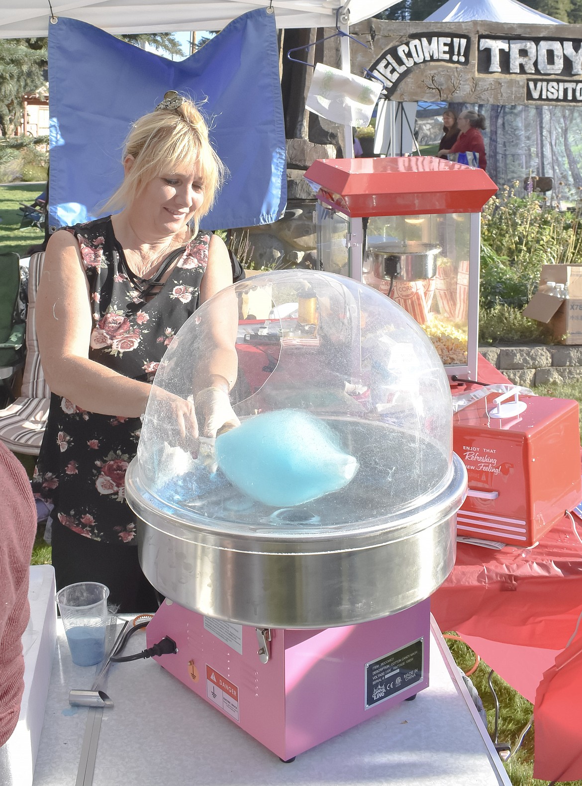 Trina Kerzman with Kootenai Kiwanis makes cotton candy Friday at the Troy Farmer&#146;s Market Apple Festival. The Kiwanis were at the festival -- as they are at other events around the area -- raising money to buy school supplies for local students. (Ben Kibbey/The Western News)