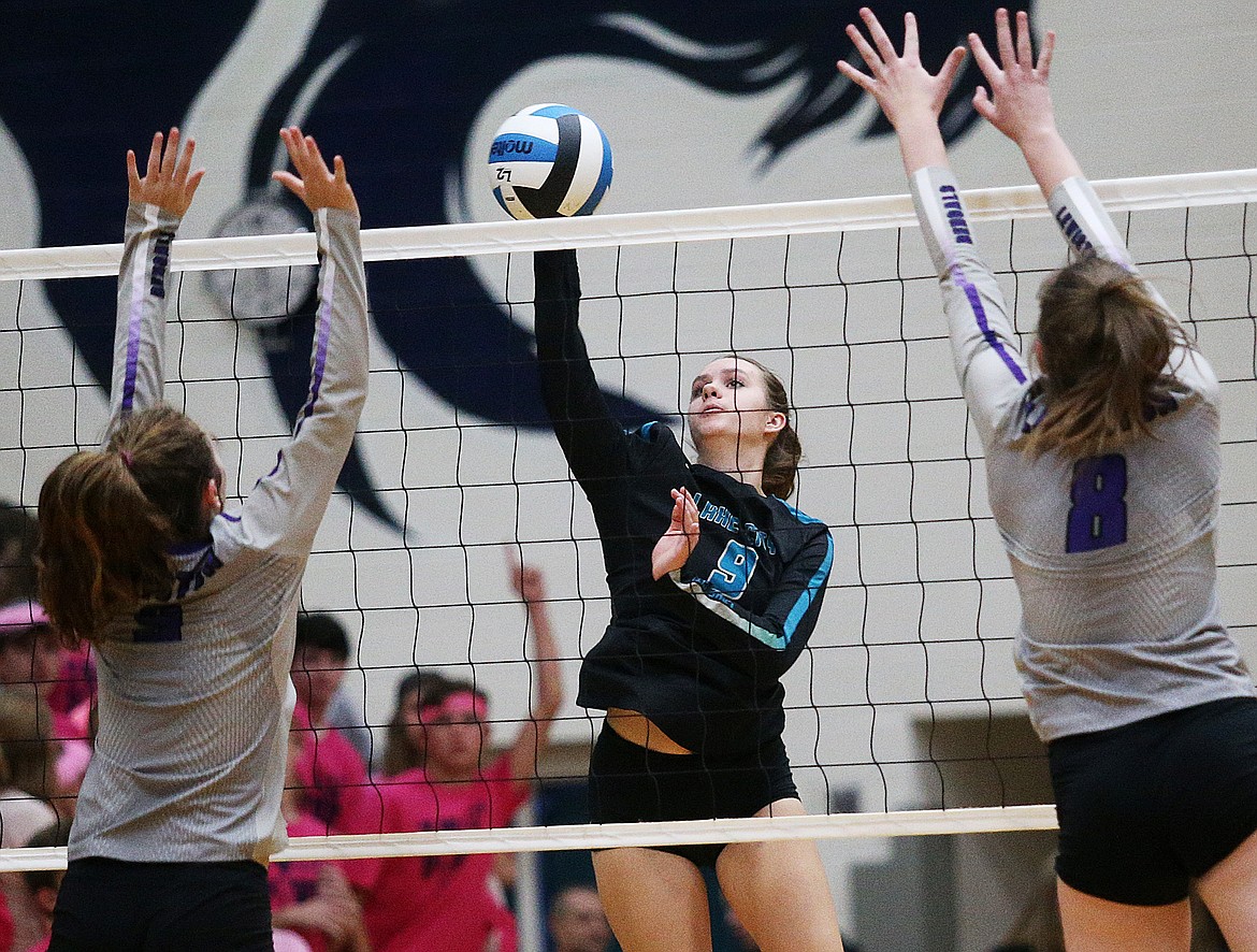 Lake City outside hitter Kayla Freed hits the volleyball between two Lewiston players in the 5A Region 1 championship match at Lake City High School. (LOREN BENOIT/Press)