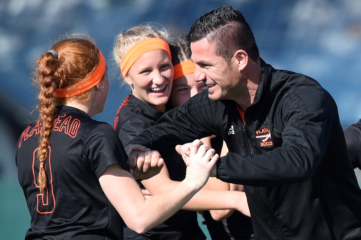 Flathead head coach Bledy Doda celebrates with Skyleigh Thompson (9) and teammates after the Bravettes 4-0 win over Helena High at Legends Stadium on Thursday. (Casey Kreider/Daily Inter Lake)