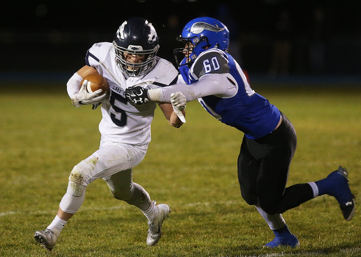 Coeur d'Alene linebacker Nick Dohm tackles Lake City running back Natheniel Hayes for a loss during Friday night's game at Coeur d'Alene High School. (LOREN BENOIT/Press)