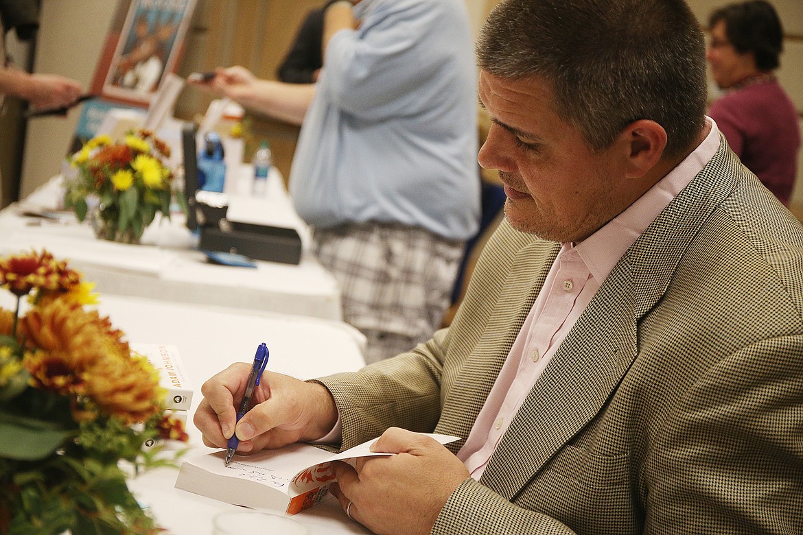 Prize winning author Adam Johnson signs &quot;The Orphan Master's Son&quot; for a fan at the 15th annual North Idaho Distinguished Humanities Lecture and Dinner at the Coeur d'Alene Resort on Thursday. (LOREN BENOIT/Press)