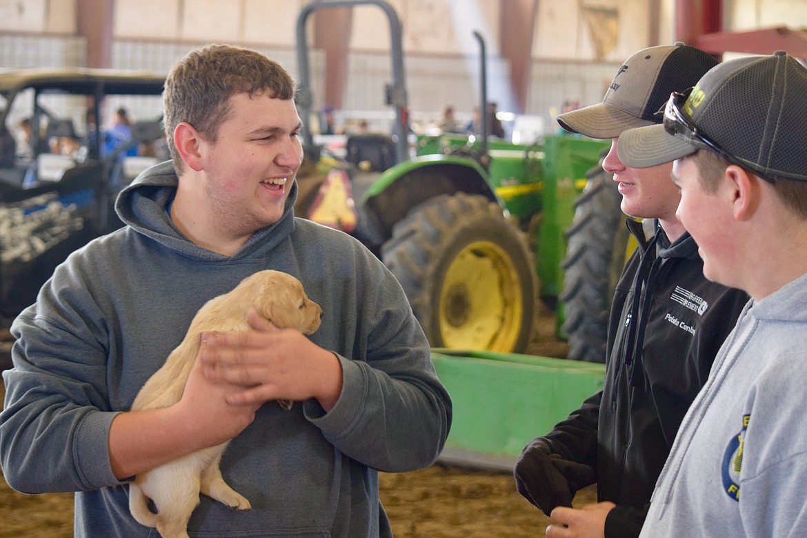 Charles H. Featherstone/Columbia Basin Herald
17-year-old Kooper Yearout laughs with some friends while holding a puppy during Farm Day on Wednesday.