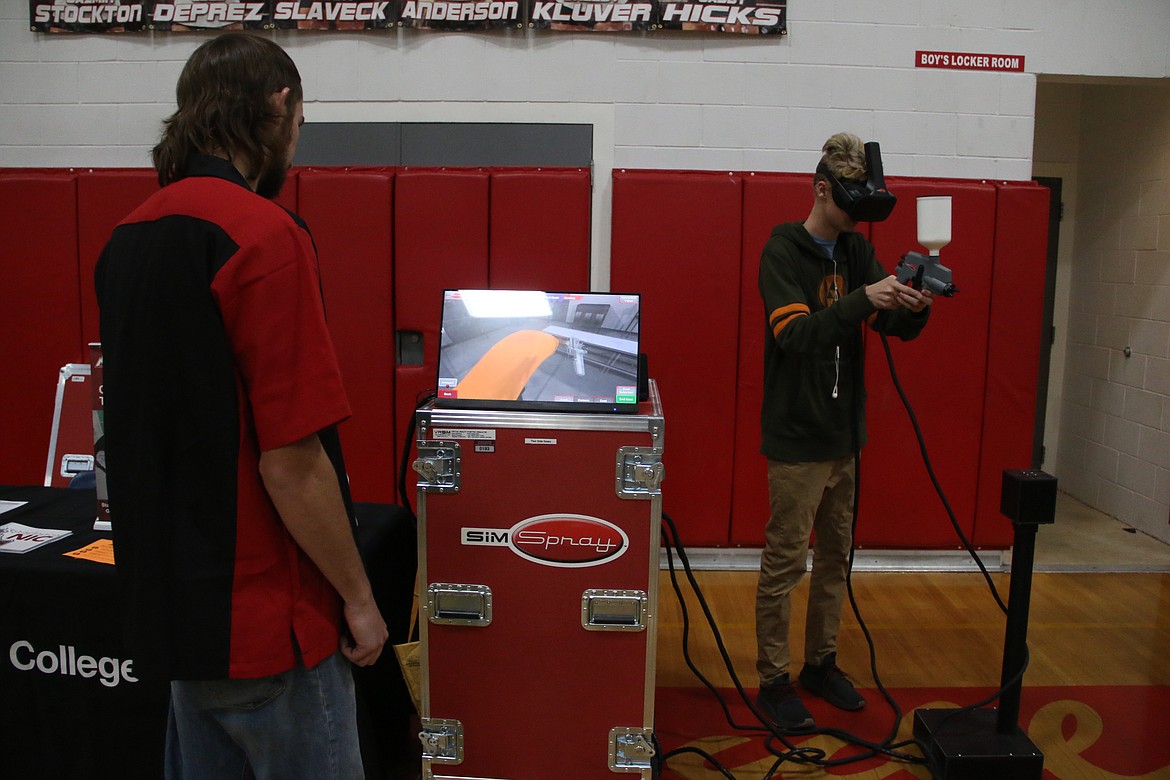 (Photo by MARY MALONE)
Sandpoint High School junior Cyrus Mimbs paints an imaginary car using a virtual reality paint sprayer during the North Idaho College CTE roadshow at SHS on Friday.