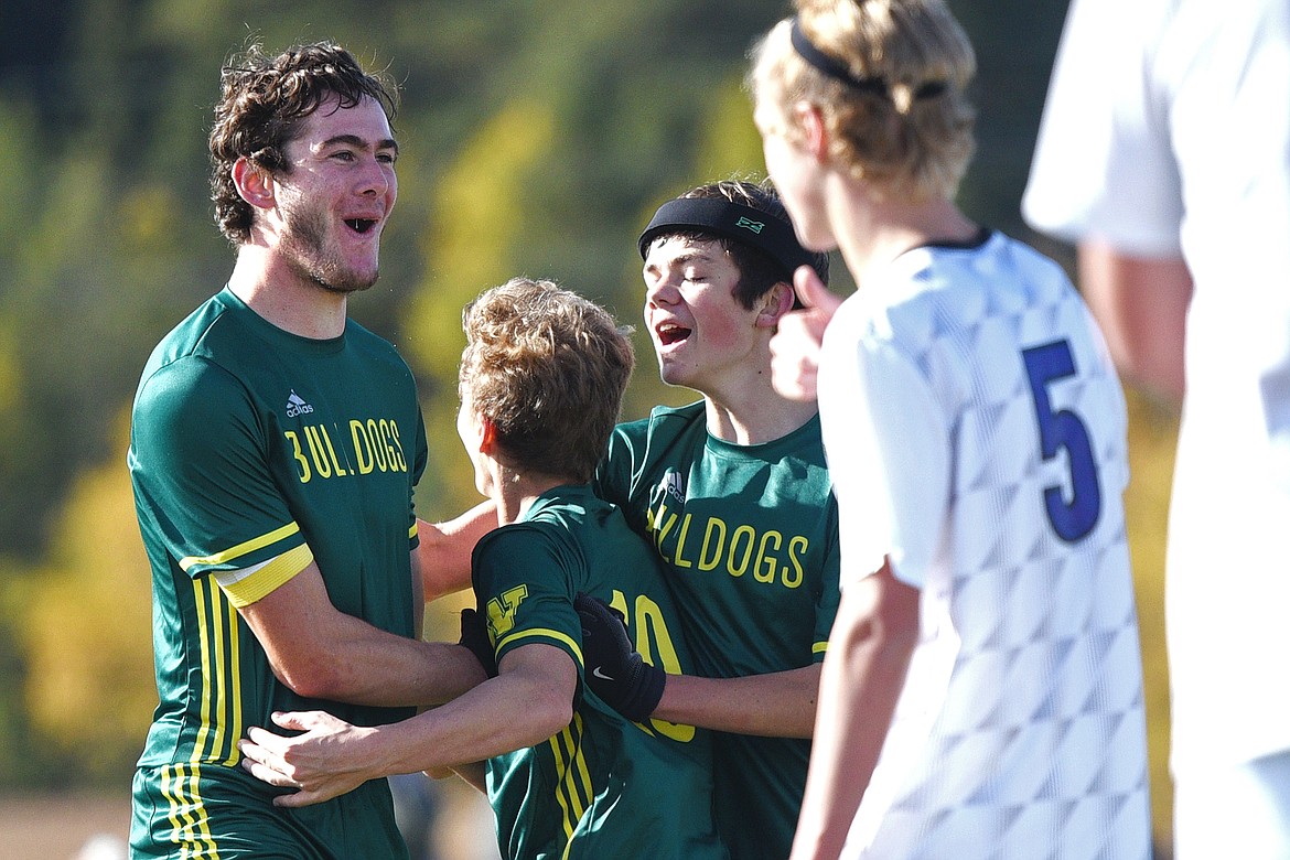 Whitefish's Sam Menicke (20) celebrates with teammates Casey Schneider (10) and Ian Lacey (7) after Menicke's first-half goal against Livingston at Smith Fields in Whitefish on Saturday. (Casey Kreider/Daily Inter Lake)