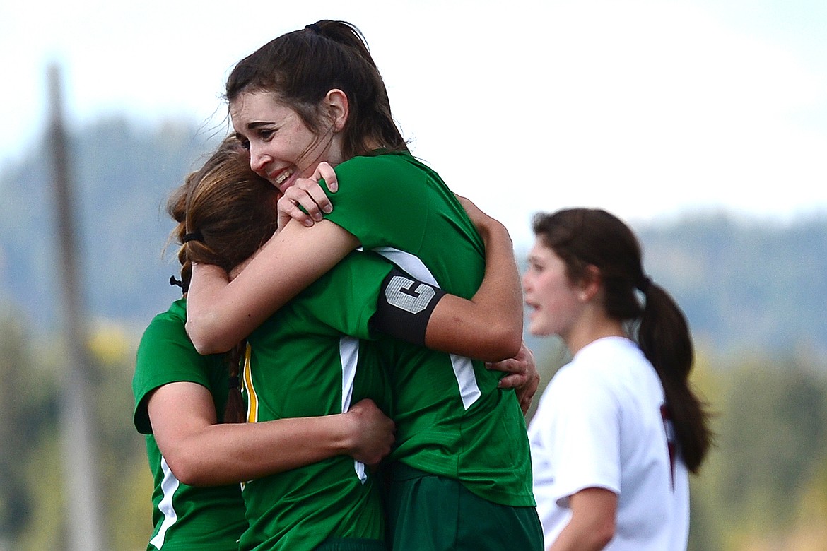 Anna Cook, center, gets a hug from teammates Olivia Potthoff, right, and Emma Barron, rear, after scoring the game-tying goal to force overtime against Hamilton at Smith Fields on Saturday. (Casey Kreider/Daily Inter Lake)