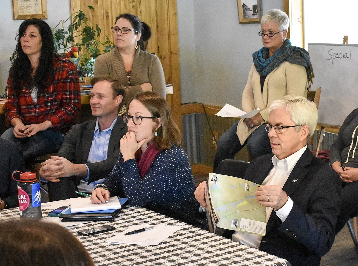 Lt. Gov. Mike Cooney tears off a Yaak Valley Forest Council map created to showcase historic and recreational aspects of Troy at a public discussion about economic development at the Silver Spur in Troy Oct. 12. (Ben Kibbey/The Western News)