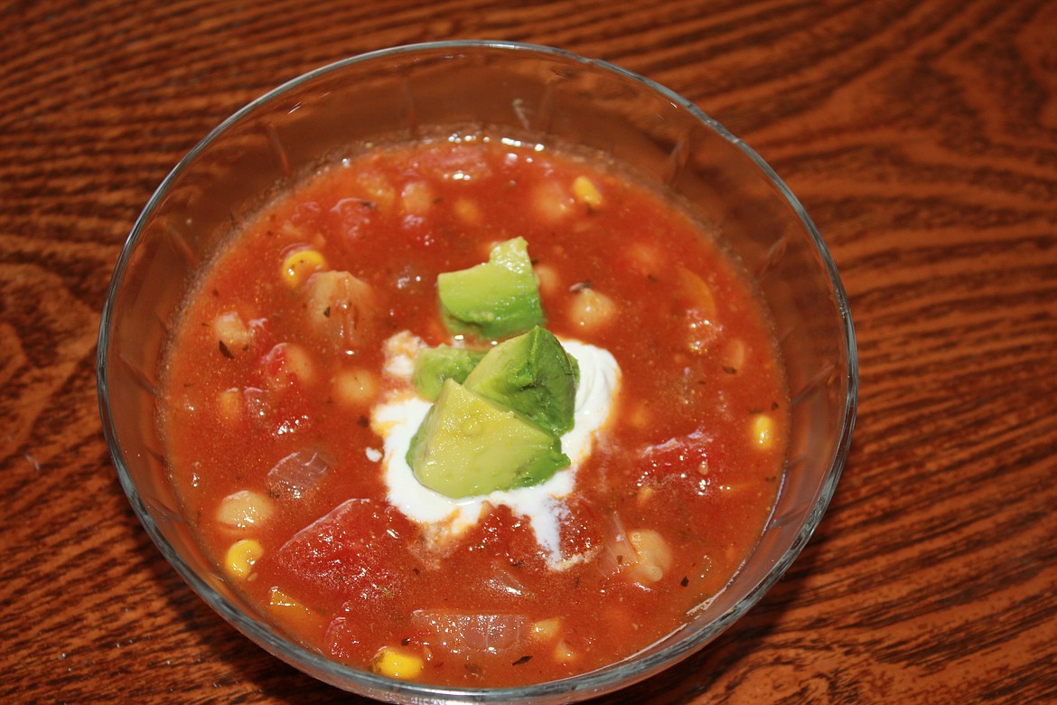 Hot Gaspatcho soup topped with sour cream and avocado.