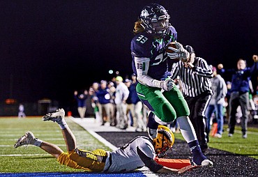Glacier running back Preston Blain (33) jumps into the end zone past Helena Capital defender Will Butler (33) on a two-point conversion that would tie the score at 14-14 before the half at Legends Stadium on Friday. (Casey Kreider/Daily Inter Lake)