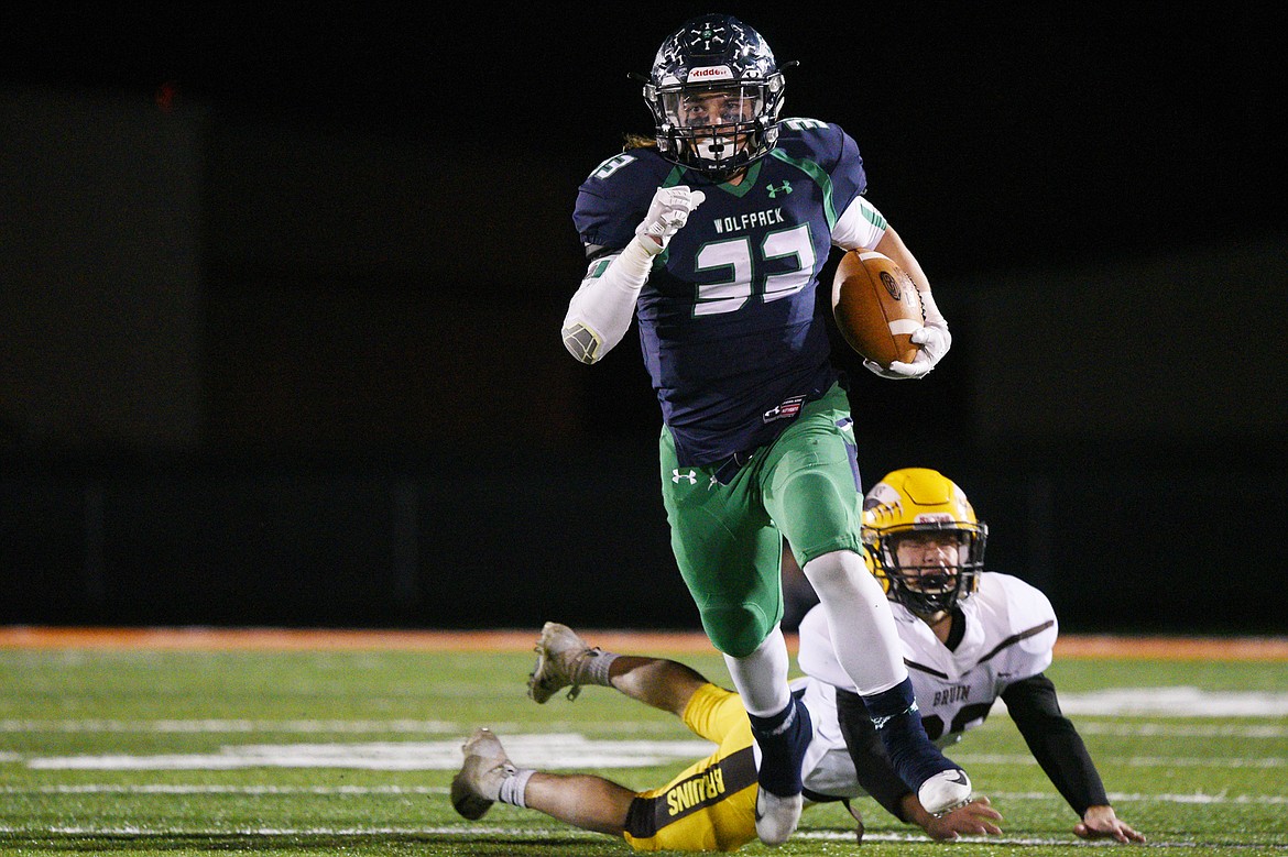 Glacier running back Preston Blain (33) gets past Helena Capital defensive back Will Butler (33) on a third quarter run at Legends Stadium on Friday. (Casey Kreider/Daily Inter Lake)