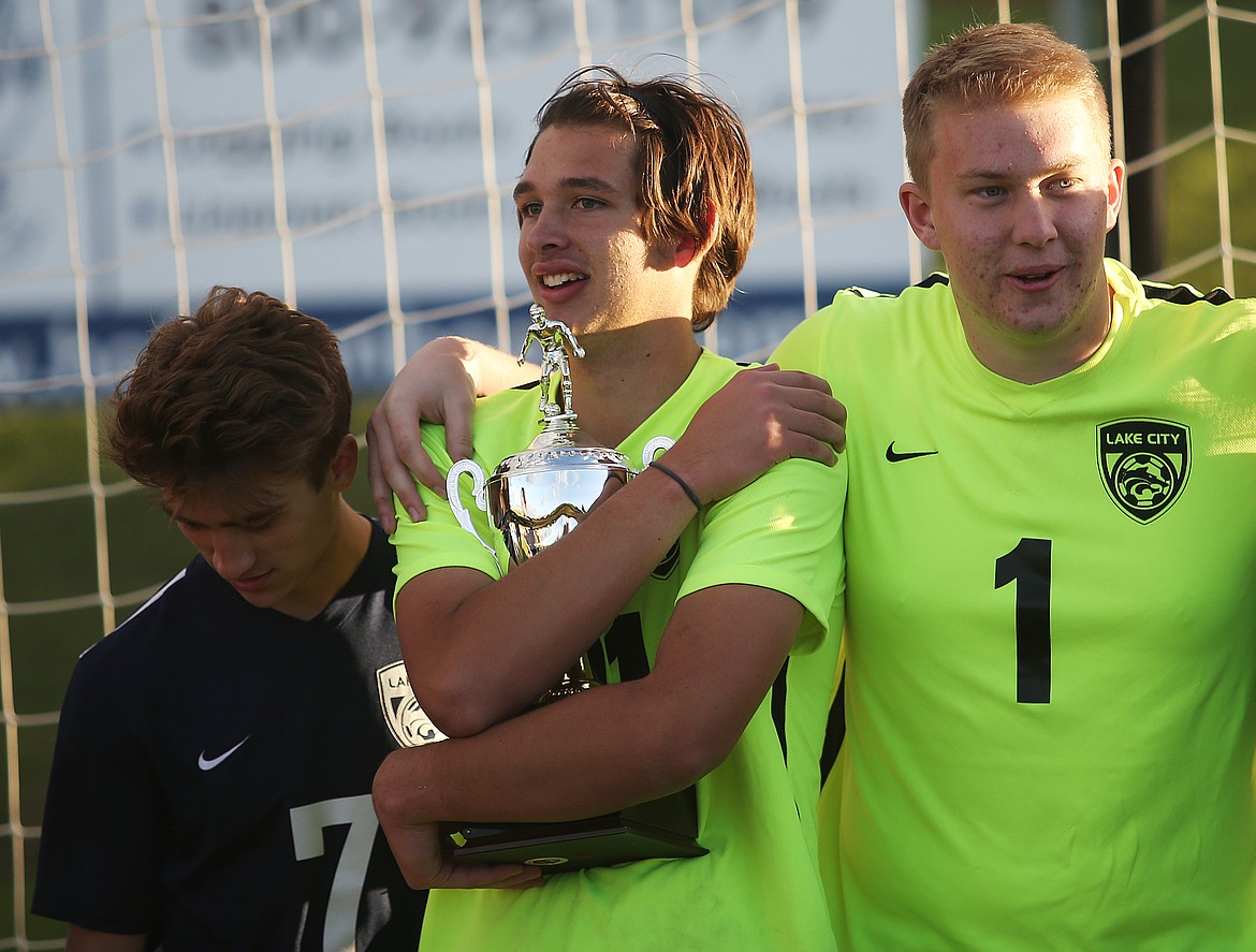 LOREN BENOIT/Press
Lake City goalkeeper Chase Norris hugs the Region 1 boys championship trophy as he stands next to Spencer Messina, left, and Aidan Hassell after defeating Coeur d&#146;Alene 3-0.