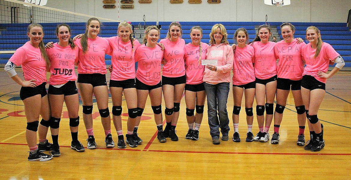 The Clark Fork Moutain Cats volleyball teams presented Mary Jo Lommen with a check for her daughter-in-law, Judi Haskins, during their match against Wallace on Oct. 8. They wore T-shirts which read, &#147;We Play 4 Judi&#148; and raised funds for her breast cancer treatments. (Kathleen Woodford/Mineral Independent)