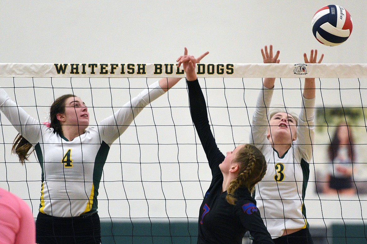 Whitefish's Luci Ridgeway (4) and Kennedy Grove (3) reach for a block against Columbia Falls at Whitefish High School on Thursday. (Casey Kreider/Daily Inter Lake)